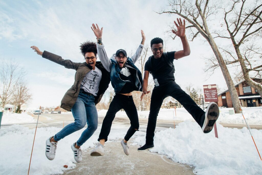 Group of friends jumping outdoors in snowy street setting